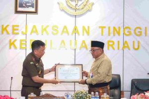 Wali Kota Tanjungpinang, Lis Darmansyah, menyerahkan piagam penghargaan kepada Kepala Kejaksaan Tinggi Kepulauan Riau, Teguh Subroto.Senggarang, Selasa (24/6/2025).